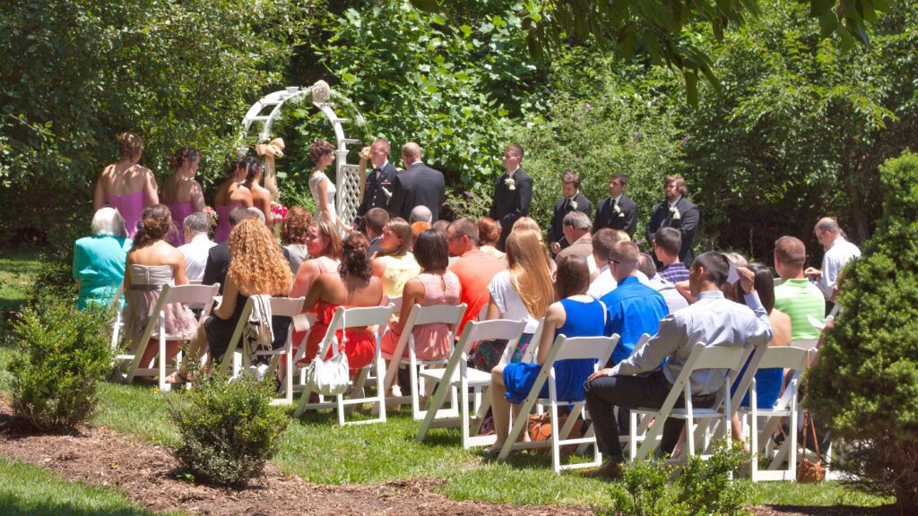 a group of people sitting in chairs at a wedding